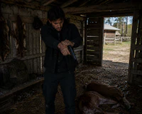 a man standing next to a deer in a barn